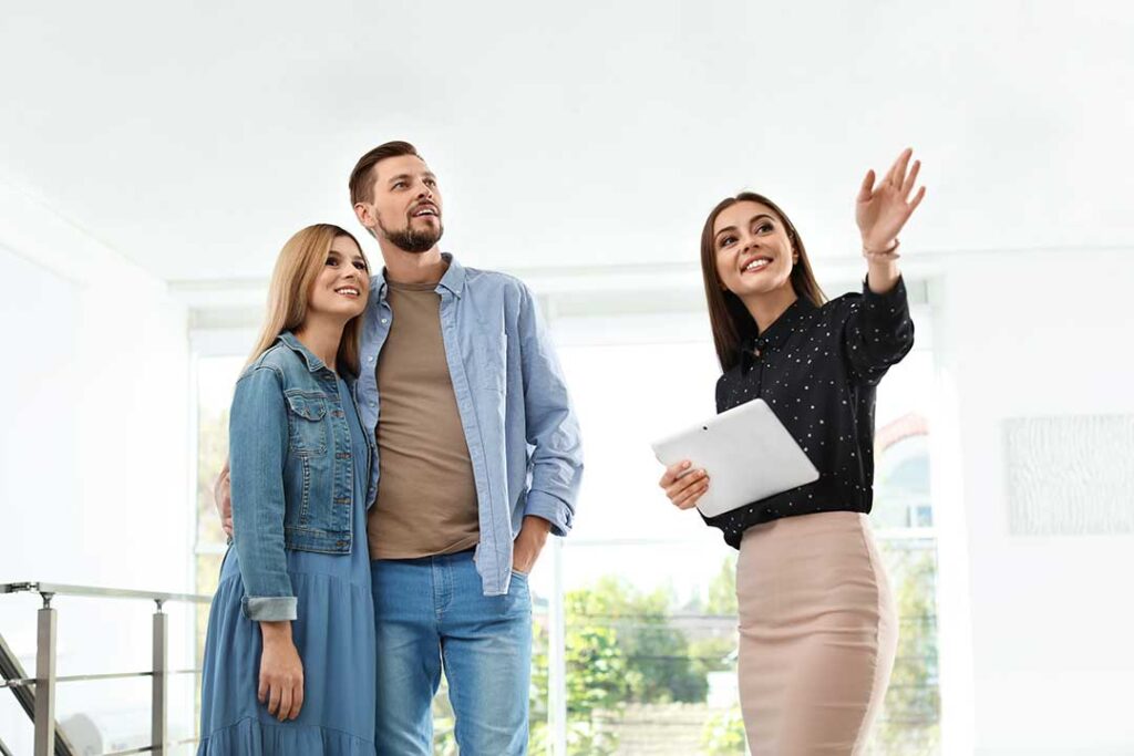 Homebuyer reviewing an agency agreement with a real estate agent at a kitchen table.